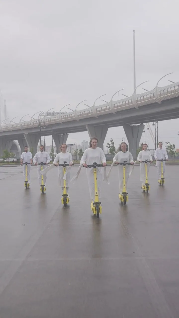 Choir riding scooters under a bridge