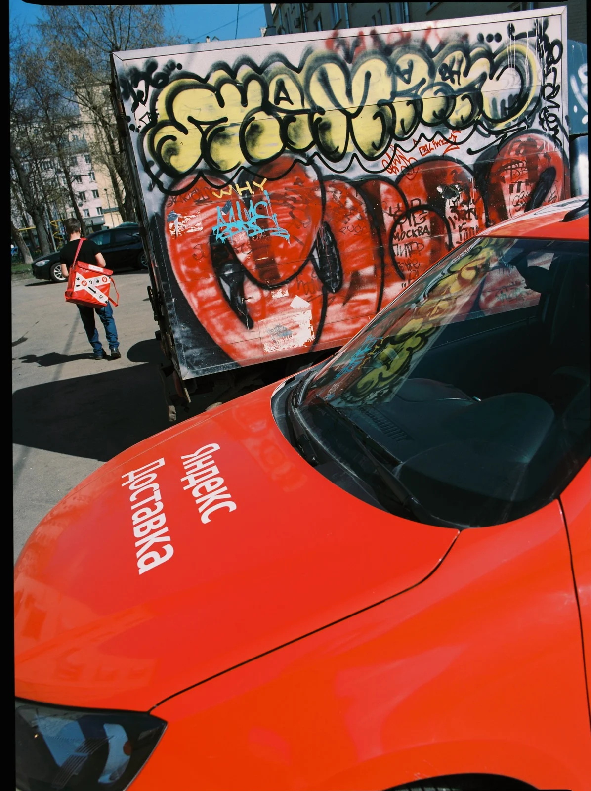 Delivery car by a graffiti truck