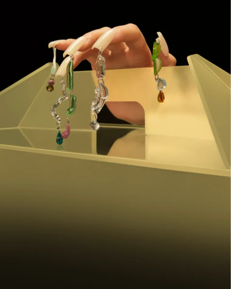 Hand lifting jewellery from a golden delivery box