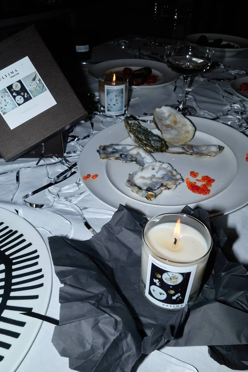 Candle on a dinner table with oysters